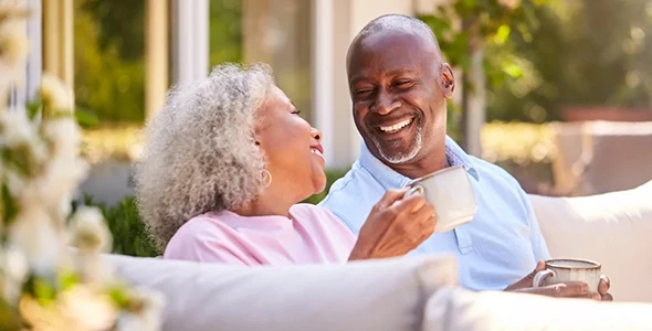 An elderly couple smiling and enjoying affordable life insurance plans for individuals and families in Dripping Springs, TX.