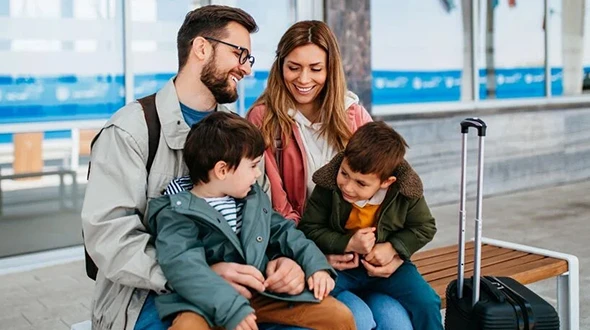 Family with luggage waiting, benefits of choosing family travel insurance.