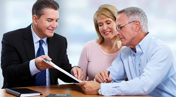 A health insurance agent assisting a couple with their insurance policy and financial planning.