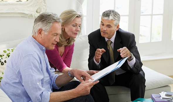 Couple reviewing retirement planning documents with their financial advisor, illustrating the benefits of retirement income planning.