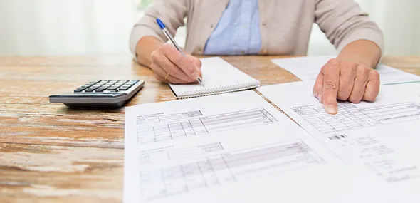 Person calculating with calculator to plan annuity services in Austin, TX.