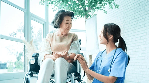 A senior woman in a hospital bed is being assisted by a health professional, symbolizing critical illness insurance for seniors in Wimberley, TX.