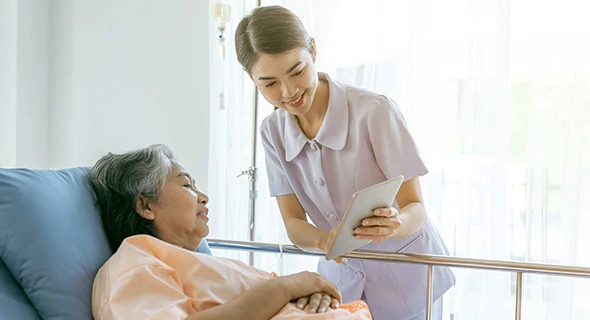 Senior woman in hospital with nurse discussing critical illness insurance with no medical exam in Dripping Springs, TX.